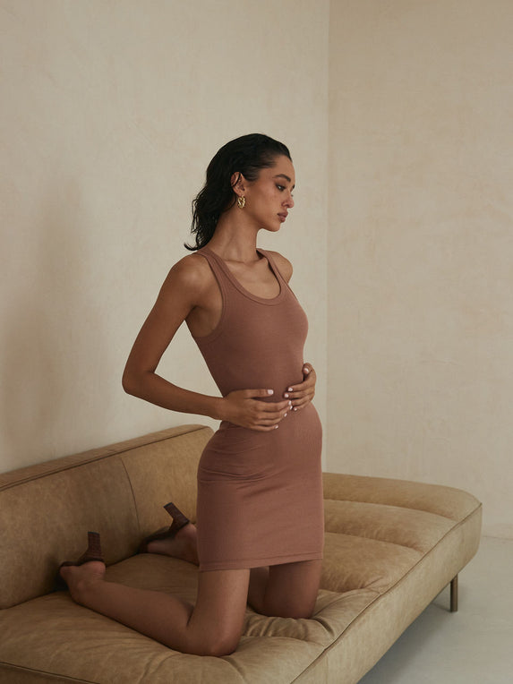 Model posing in a Jenna Midi bronze dress from Clyque.