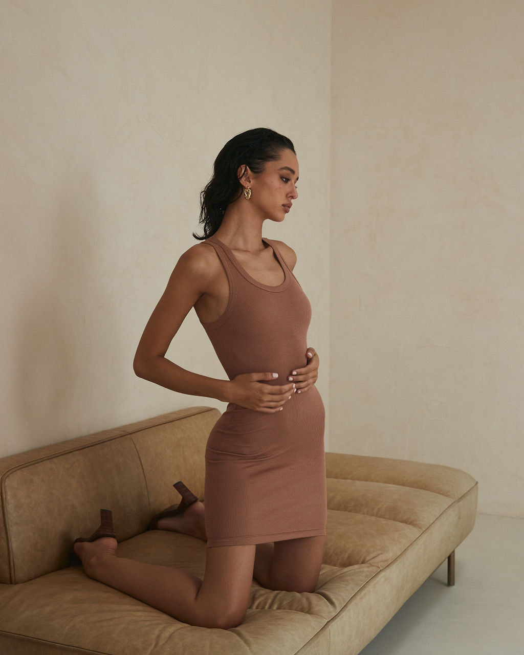 Model posing in a Jenna Midi bronze dress from Clyque.